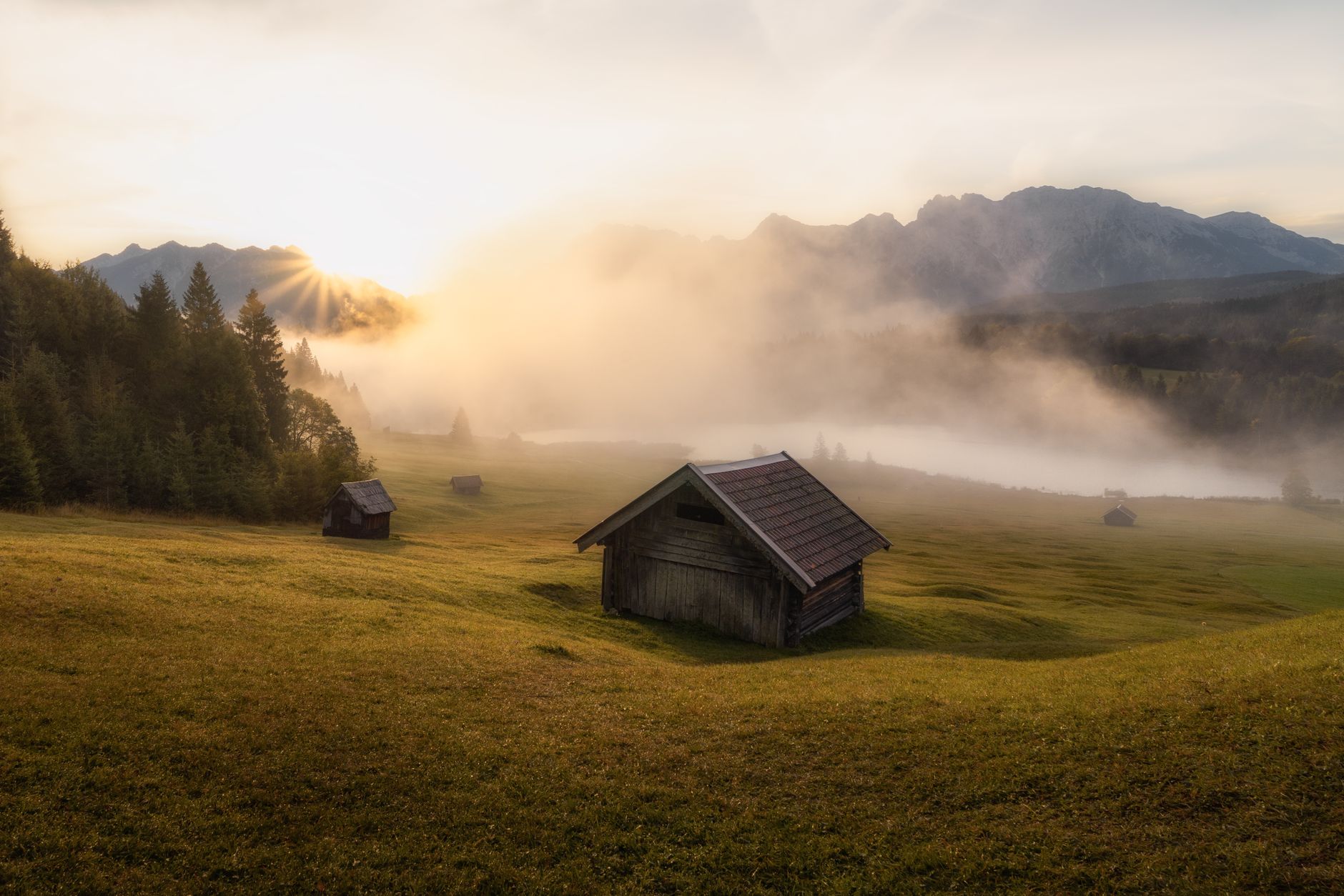 Alpine cabin in sunrise mist